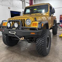 a yellow jeep is parked in a garage