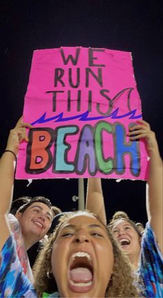 young people holding up a sign that says we run this beach