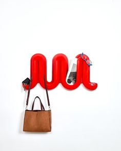 a red balloon with the word july hanging on it's side next to a brown bag