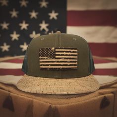 Elevate your outdoor style with the 'Merica Distressed Flag Flat or Curved Bill Snapback by KORKIT Company featuring a precision-engraved cork patch, breathable lightweight mesh, Cork Bill, and 6 Panel Construction. Crown: 60% Cotton / 20% Linen / 20% Polyester Visor: 100% Cork & Polyurethane 6 Panel Structured 8 Rows Stitching on Visor Plastic Snap Closure  OSFM - Adult (6 1/2 - 7 5/8) Crown Height - Mid Profile: 8.6 cm / 3.4" Patriotic Baseball Cap For Outdoor, Adjustable Patriotic Hat For Outdoors, Patriotic Outdoor Baseball Cap, Rustic Outdoor Cap, Adjustable Patriotic Outdoor Hat, Patriotic Adjustable Baseball Cap For Outdoor, Adjustable Patriotic Hat With Flat Bill, Flat Bill Hats Made In Usa For Outdoor, Outdoor Flat Bill Hats Made In Usa