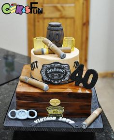 a birthday cake made to look like an old trunk with cigars and bottles on top