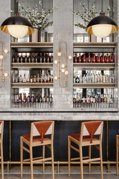 the bar is lined with liquor bottles and chairs