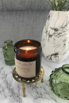 a candle sitting on top of a table next to vases