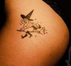 a small tattoo on the back of a woman's stomach shows a witch riding a broom