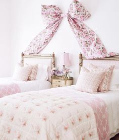 two beds with pink and white comforters in a bedroom