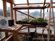 the inside of a greenhouse with several plants in pots and an air conditioner on top