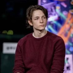 a young man sitting on top of a chair