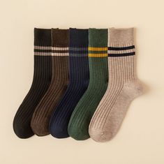 five pairs of socks hanging on the wall, all in different colors and patterns with stripes