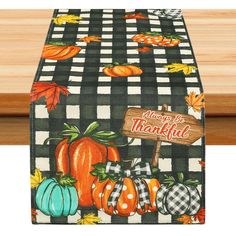 a black and white checkered table runner with pumpkins on it