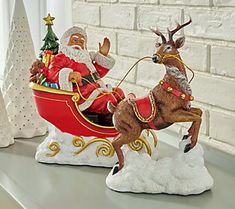 a santa claus riding in a sleigh with reindeer on the roof and other decorations