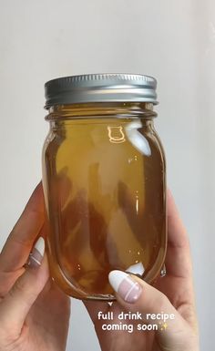 a woman holding a jar full of liquid with the words, full drink recipe coming soon