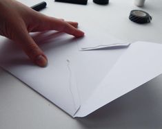 a person's hand on top of a piece of paper