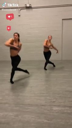 two women are dancing in an empty room