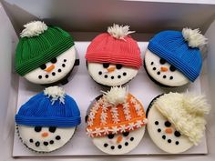 six cupcakes decorated like snowmen with hats and scarves in a box