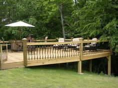 a wooden deck with chairs and an umbrella