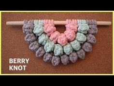 a crocheted heart is hanging on a knitting needle with the words berry knot written across it