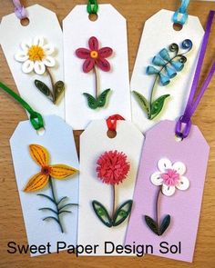 four tags with flowers on them sitting on a table