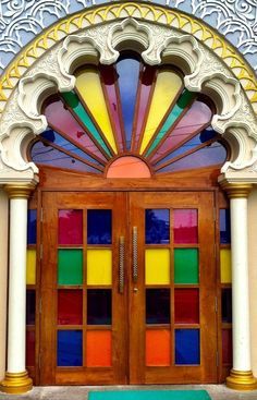 the front entrance to a building with stained glass doors