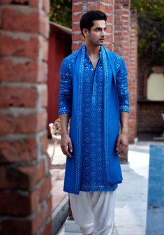 Editor's Note Elevate your style with our azure blue mirror work kurta, designed to make a statement at sangeet occasions. The vibrant blue hue and intricate mirror work detailing add a touch o... Kurta With Stole Men, Blue Kurta Men, Stole For Men, White Salwar, Intricate Mirror, Indian Wedding Clothes For Men, Danish Image