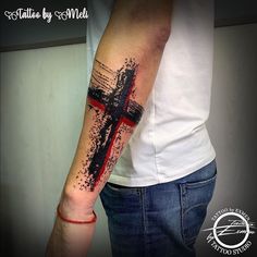 a man with a cross tattoo on his arm