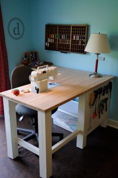 a sewing machine sitting on top of a wooden table next to a lamp and chair