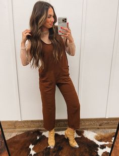 Saddle up in our Trouble Town Brown Jumpsuit and take on the Wild West in style. With its versatile design, this jumpsuit can be dressed up with cowboy boots and a hat for a night out, or dressed down with sneakers for a more casual look. Made with comfortable and durable materials, this jumpsuit is perfect for any adventure in the town or on the ranch. Deep, V Neck, Solid, Loose Fit Jumpsuit, With Adjustable Straps And Front Pockets. Fit: fits true size, model wearing small Material: 95% Poly, 5% Spandex Western Romper Outfit, Western Romper, Brown Jumpsuit, Loose Fit Jumpsuit, Brown Jumpsuits, The Wild West, The Ranch, Turks And Caicos Islands, Dressed Down