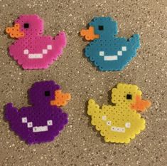 four perlery rubber ducks sitting on top of a counter next to each other