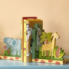 two children's books are sitting on a shelf with an elephant and giraffe bookends