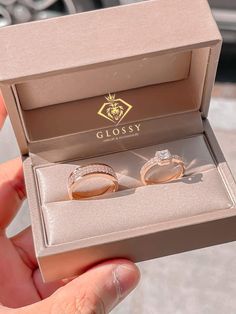 two wedding rings in a box with the lid open to show it's inside