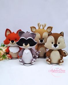 three stuffed animals are standing next to each other on a white surface with flowers in the background