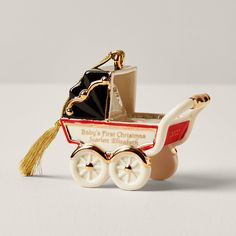 an ornament shaped like a baby's first christmas carriage with a tassel