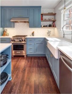 a kitchen with blue cabinets and wooden floors