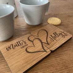 two mugs and a cookie on a table with the name matry's coffee