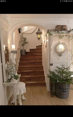 an entry way with stairs and potted plants