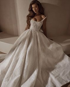 a woman in a white wedding dress sitting on the floor