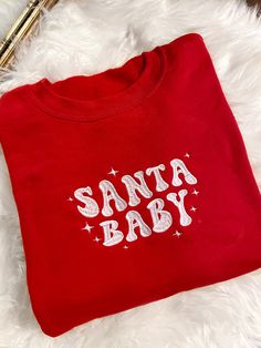 Get festive with our Santa Baby Crewneck Sweatshirt! The Unisex Sizing makes the sweatshirt run slightly larger than your average sweatshirt for women. Most men find their normal size to be more snug. If you want a slightly looser fit, size up one size. Please check out our size chart for measurements to ensure an accurate fit. PLEASE BE SURE TO INPUT YOUR CORRECT SIZE/COLOR + SHIPPING ADDRESS. We will not be responsible if it is incorrect! Refunds/Exchanges accepted, please read our Refund Poli Retro Christmas Sweatshirt, Christmas Crewneck Sweatshirt Cricut, Winter Sweatshirt Ideas, Cute Christmas Sweatshirts, Christmas Embroidery Sweatshirts, Embroidered Clothes Ideas, Christmas Clothes Ideas, Christmas Sweaters Aesthetic, Vinyl Sweatshirt Ideas