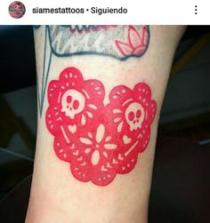 a red tattoo with skulls and hearts on it