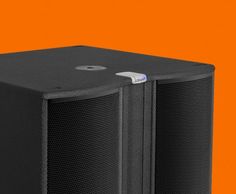 two black speakers sitting side by side on an orange background