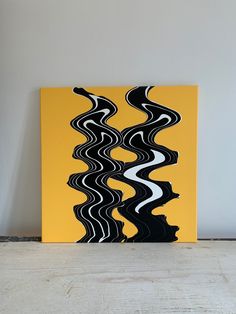 a yellow and black abstract painting on a white wall