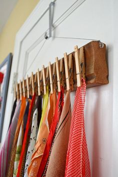 an image of clothes hanging on a rack in front of a wall mounted coat rack