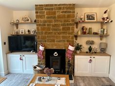 a living room filled with furniture and a fire place in front of a flat screen tv