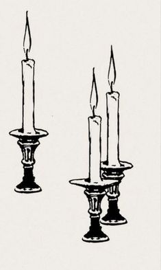 three lit candles sitting next to each other on top of a white surface with black ink