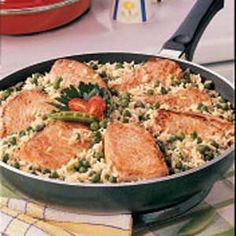 a pan filled with rice and vegetables on top of a table