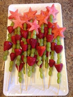 strawberries and grapes are arranged on sticks with stars