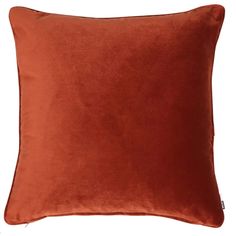 an orange velvet pillow on a white background