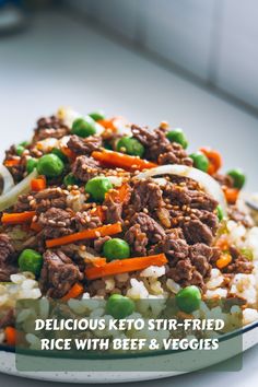 Keto stir-fried rice with beef, peas, and carrots topped with sesame seeds.