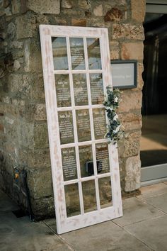 an old window is decorated with greenery for a wedding ceremony at the stone building