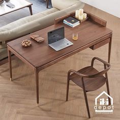 a laptop computer sitting on top of a wooden table next to a chair and couch