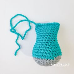 a crocheted blue and gray purse on a white surface with a string attached to it