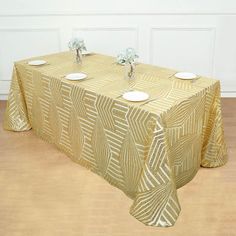 a gold table cloth with white plates on it